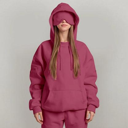Person wearing a maroon hoodie and matching pants on a plain background